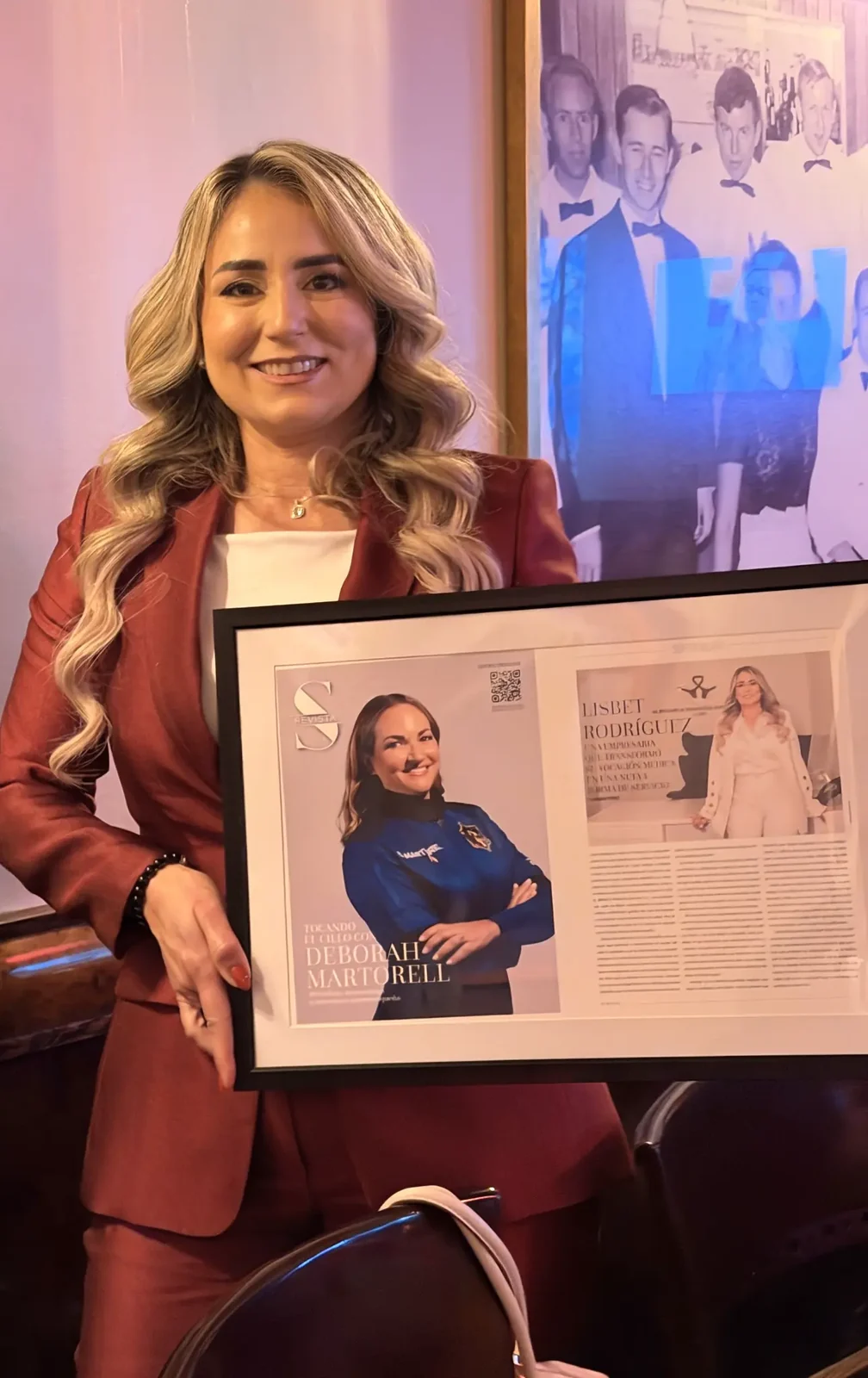 LL Billing CEO Lisbet Rodríguez holding the framed S Revista feature recognizing her as a Súper Mujer